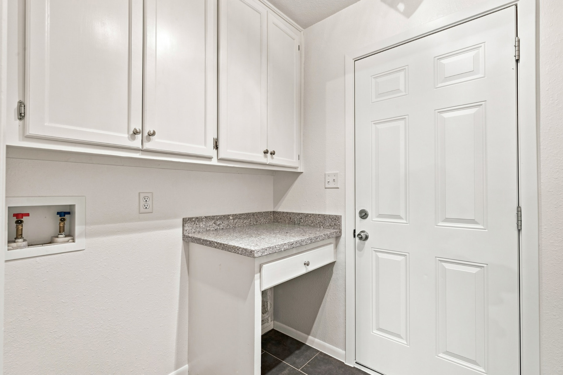 Laundry room with cabinetry, folding counter, and garage access