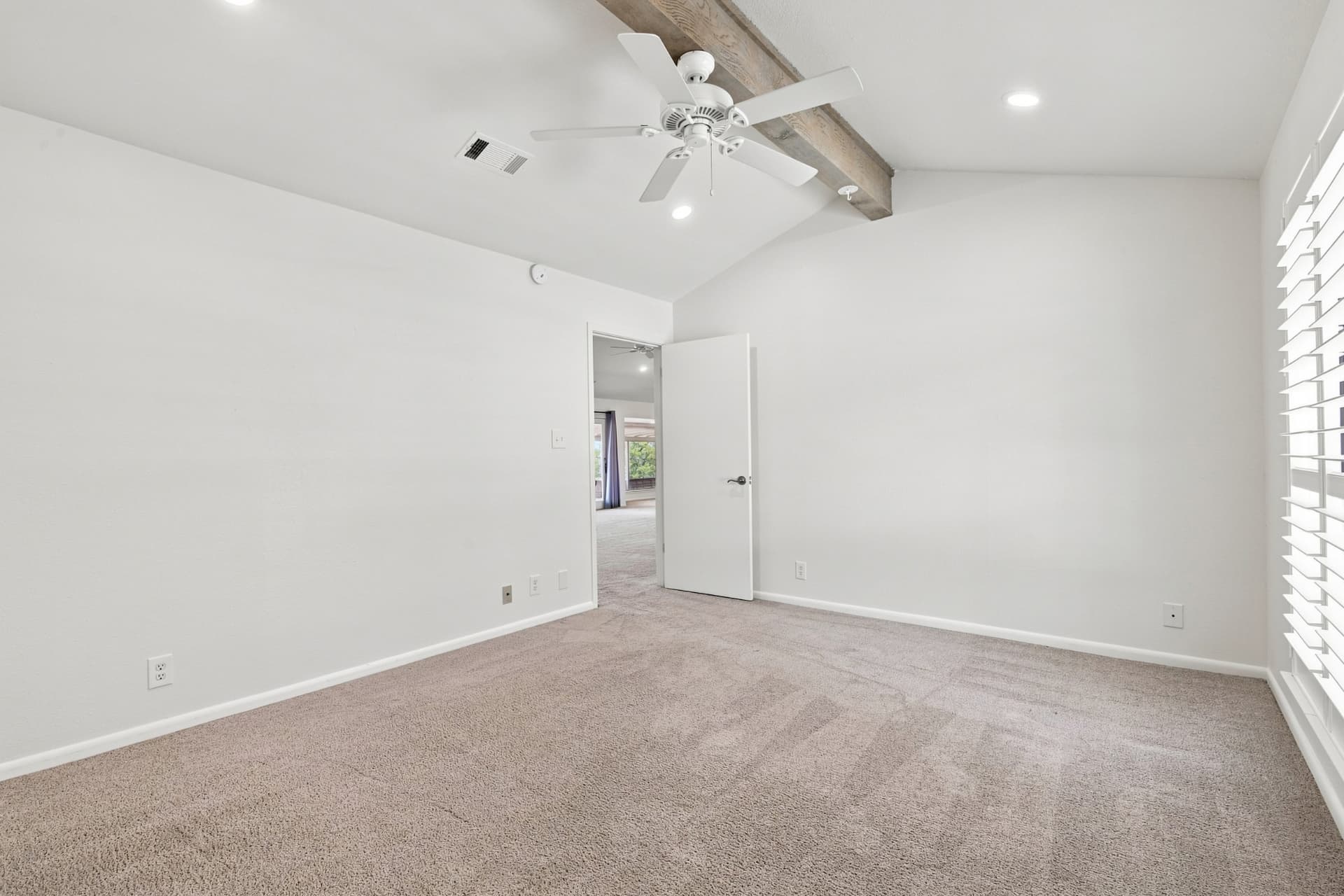 Bedroom with vaulted beamed ceiling and shuttered window