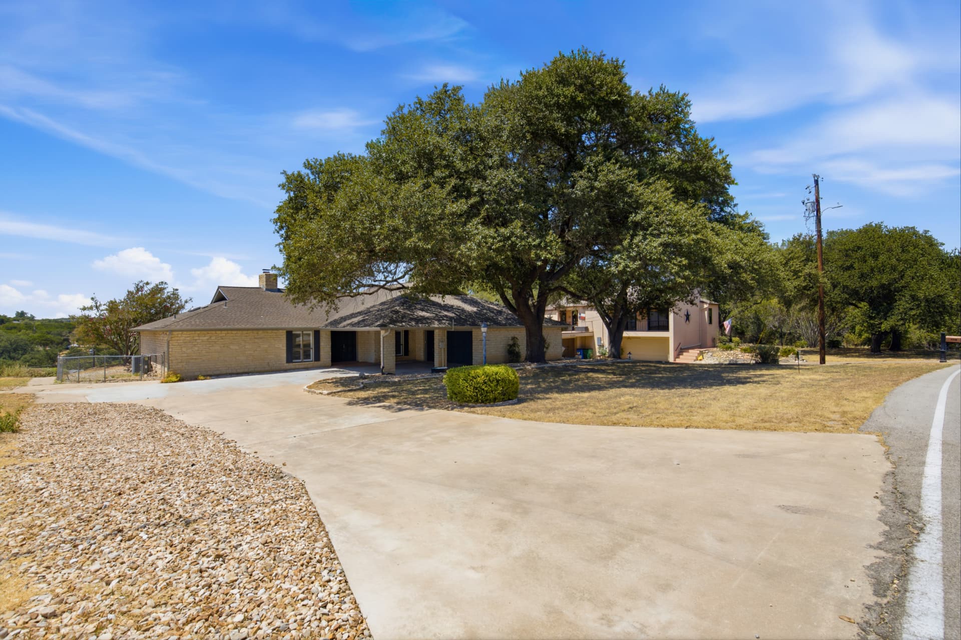 Wide front view with mature oak tree and circular drive
