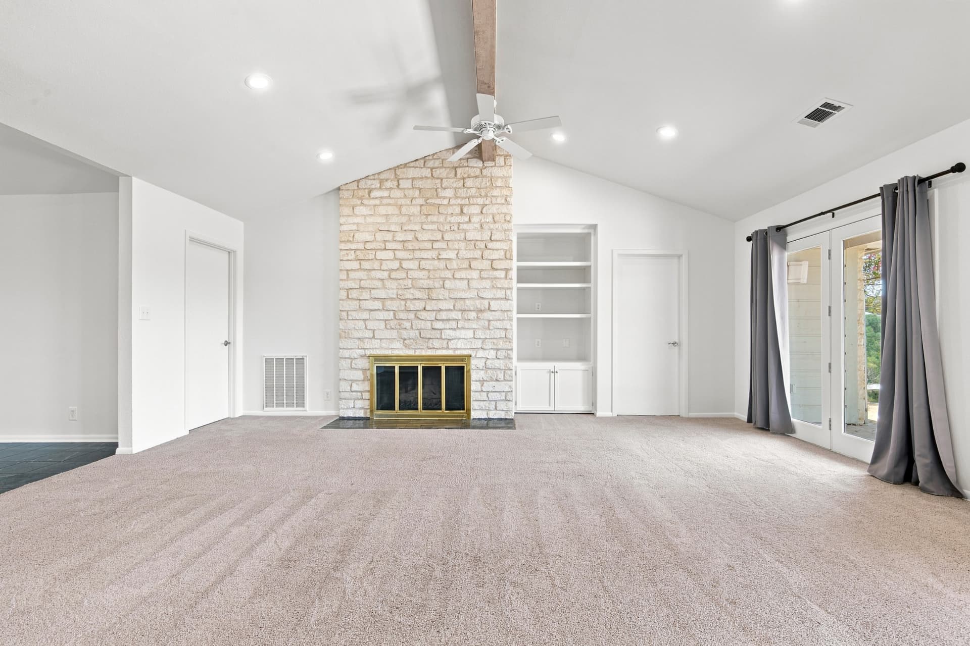 Living room from another angle showing the stone fireplace