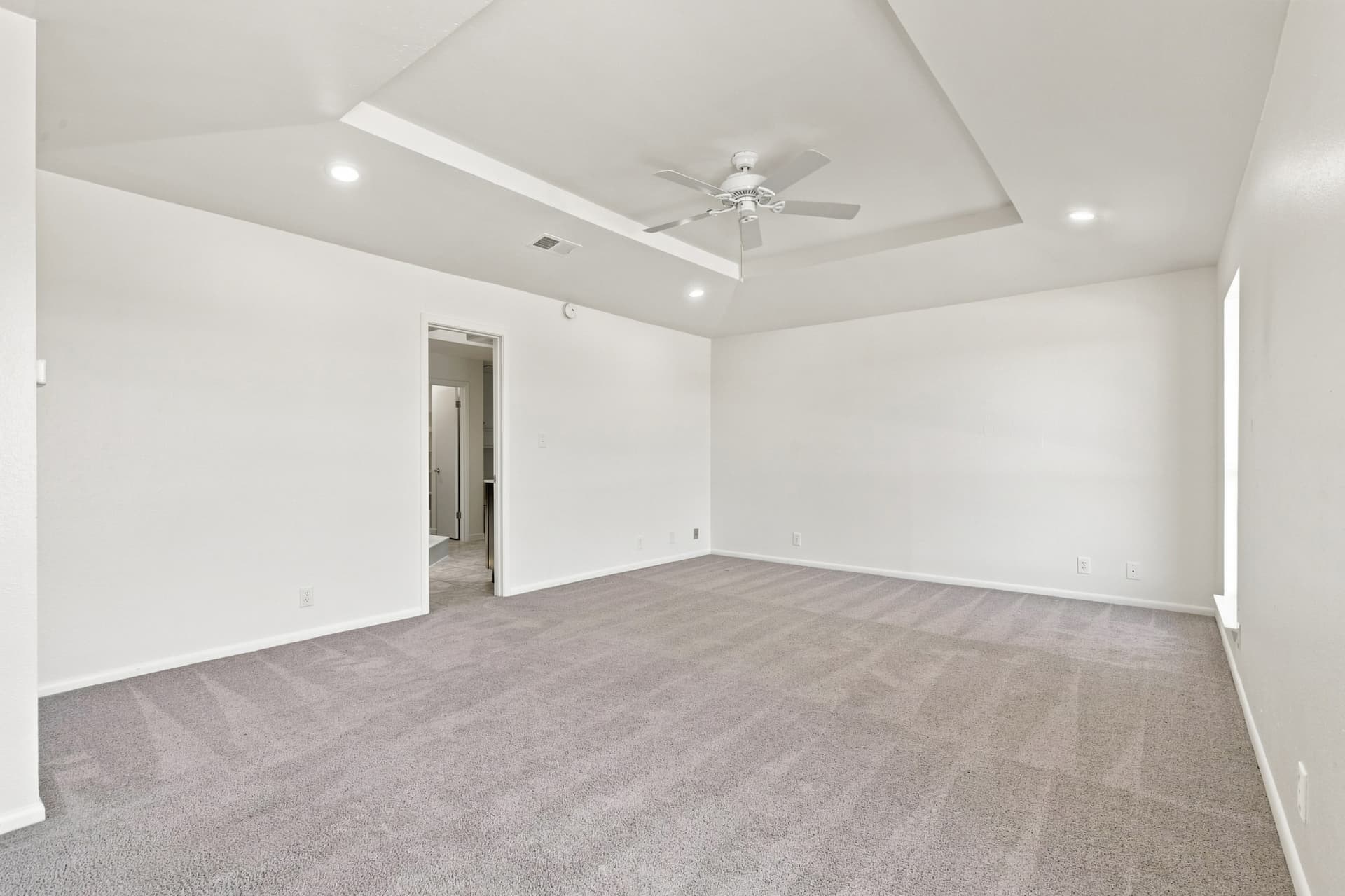 Spacious bedroom with tray ceiling and en-suite access
