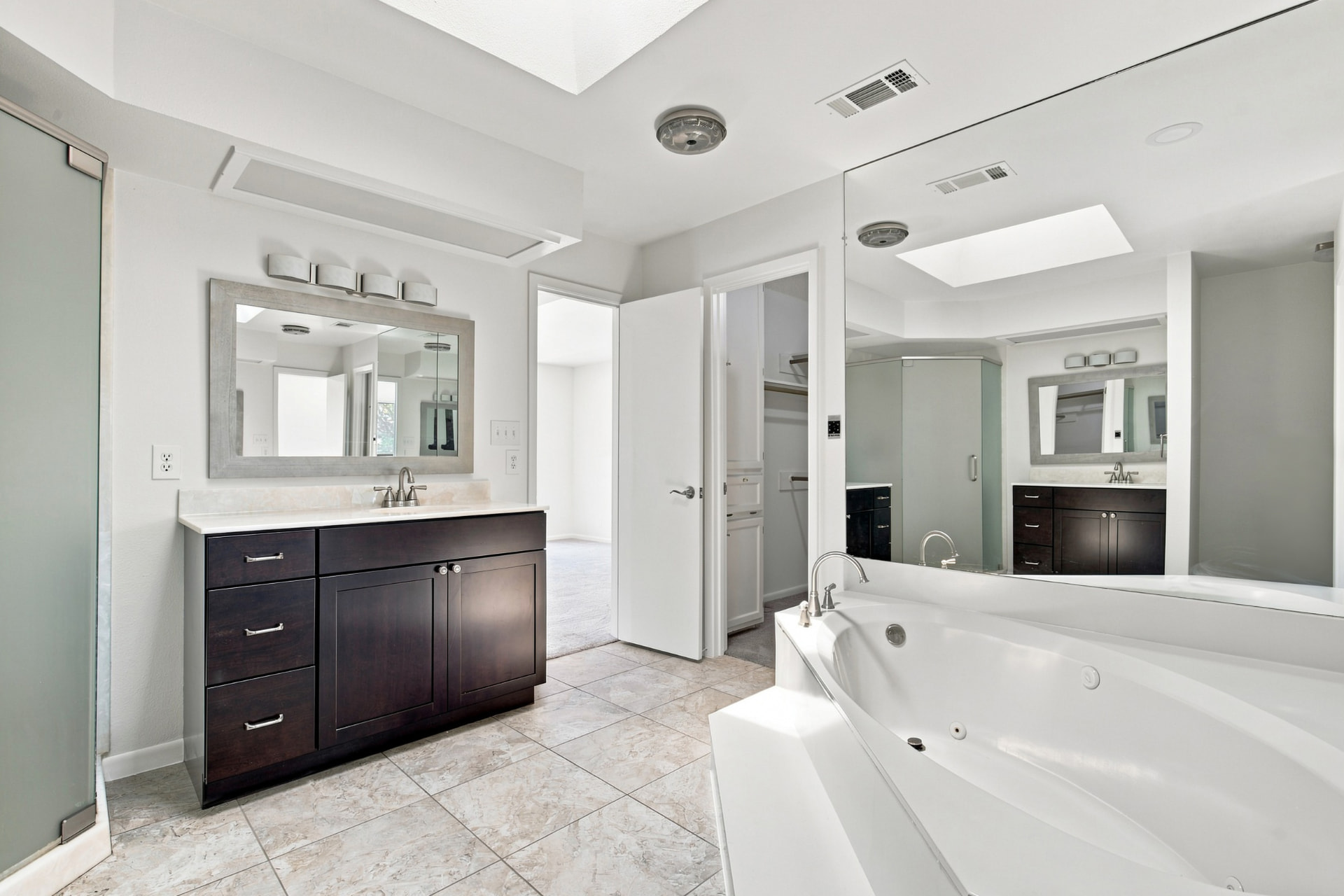 Bath vanity with framed mirror and walk-in closet access
